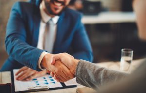 Close up of business handshake in the office. Selective focus on hands
