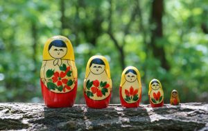 Matryoshka figures on a green colored background.