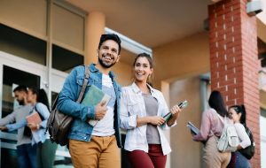 Happy university student and his female friend walking after the lecture at campus.