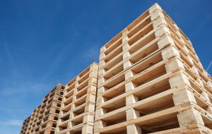 stack of wooden pallets against clear blue sky, low angle view