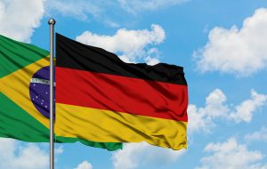 Brazil and Germany flag waving in the wind against white cloudy blue sky together. Diplomacy concept, international relations.