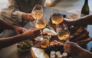 Friends having wine tasting or celebrating event with wine